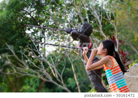 Asian girl enjoying with barbarian statue in the Asian girl enjoying with barbarian statue in the 50161472