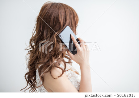 Model beautiful woman with white lace dress on white background holding mobile phone 50162013