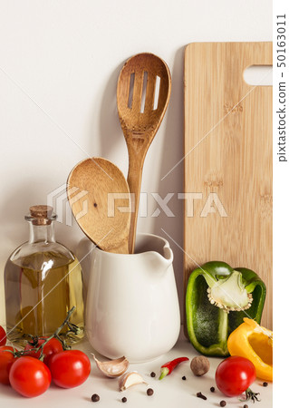 Wooden Kitchenware, vegetables and olive oil on table wall background Wooden Kitchenware, vegetables and olive oil on table wall background 50163011