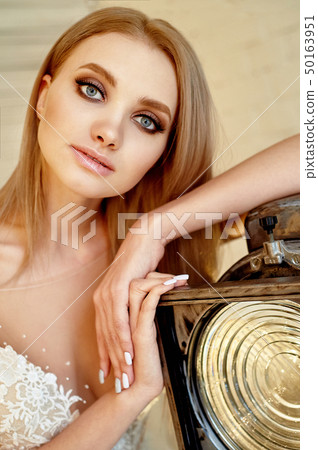 Portrait of a beautiful bride in a lace dress.Makeup smoky eyes, emphasis on eyes. Long flowing hair 50163951