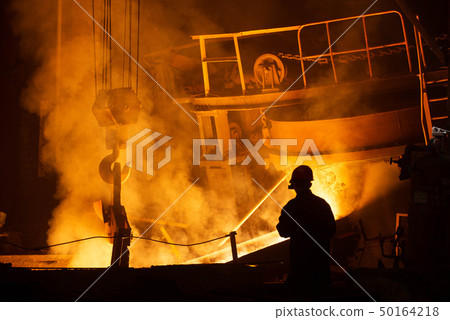 Worker controlling metal melting in furnaces 50164218