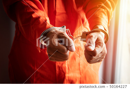 close up of prisoner's hands with handcuffs 50164227