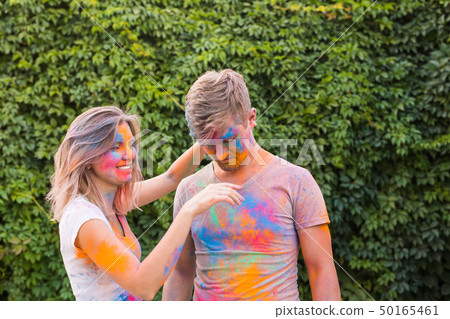 Friendship, festival of holi - young woman play with dirty t-shirt of young man at the festival of Friendship, festival of holi - young woman play with dirty t-shirt of young man at the festival of 50165461