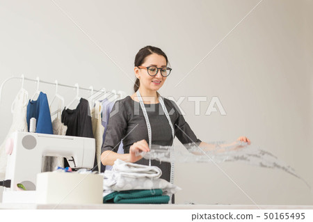 Dressmaker, fashion designer and tailor concept - Fashion designer woman working in the studio Dressmaker, fashion designer and tailor concept - Fashion designer woman working in the studio 50165495