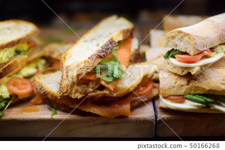 Fresh sandwiches on wooden cutting board in window Fresh sandwiches on wooden cutting board in window 50166268