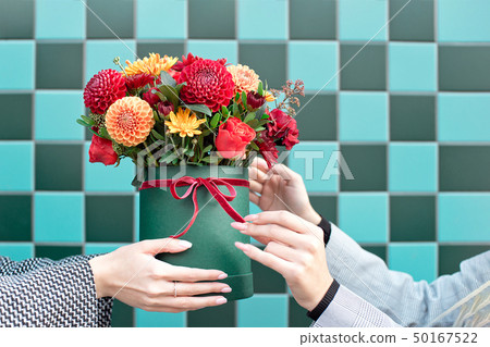 Young woman receiving beautiful peony flowers from delivery woman. Young woman receiving beautiful peony flowers from delivery woman. 50167522