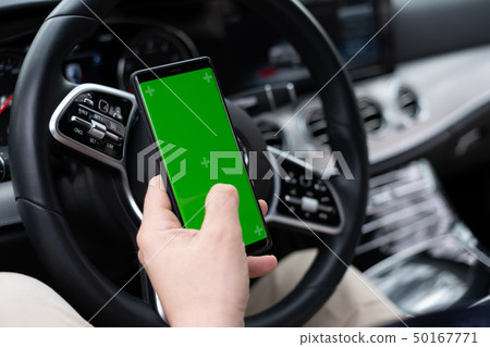 Man hold smartphone in car on dashboard background 50167771