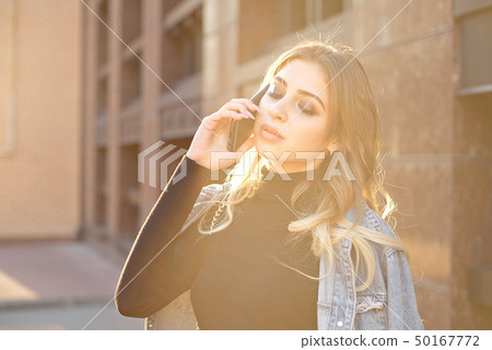 Emotional stylish portrait of a young blond woman on a cityscape background close-up in the setting Emotional stylish portrait of a young blond woman on a cityscape background close-up in the setting 50167772