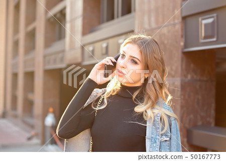 Emotional stylish portrait of a young blond woman on a cityscape background close-up in the setting Emotional stylish portrait of a young blond woman on a cityscape background close-up in the setting 50167773