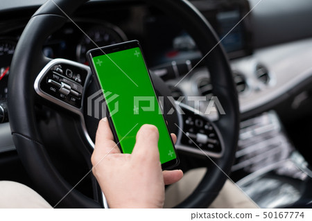 Man hold smartphone in car on dashboard background 50167774