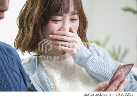 Couple looking at a smartphone together 50168295