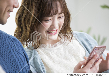 Couple looking at a smartphone together 50168296