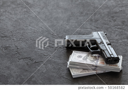 Pistol and money. Guns and dollars on black background. Copy space for text. 50168582