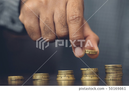 Saving money. businessman hand putting stack  50169861