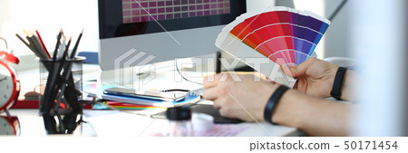 Male serviceman hold in hand fantail making colour test at worktable 50171454