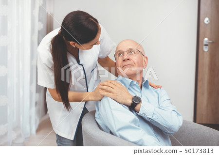 Smiling nurse and old senior man patient at home 50173813