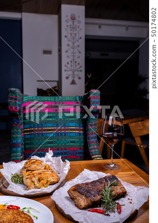 Different meat and a glass of wine in the interior of the restaurant 50174802