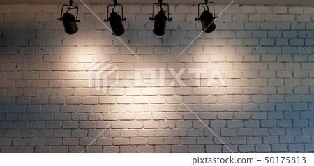 Hanging spotlight illuminate at white brick wall Hanging spotlight illuminate at white brick wall 50175813