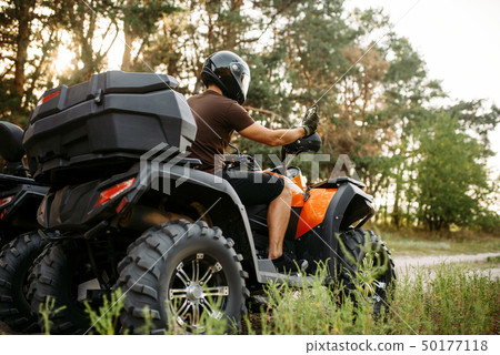 Rider in helmet on quad bike, front view, closeup Rider in helmet on quad bike, front view, closeup 50177118