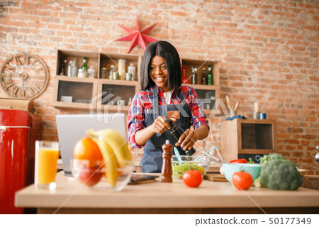 Black woman in apron cooking healthy breakfast 50177349