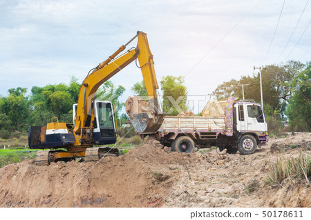 Yellow excavator machine loading soil into a dump Yellow excavator machine loading soil into a dump 50178611