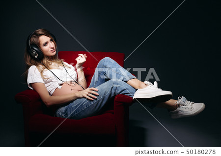 Beautiful pregnant woman sitting on red chair and 50180278
