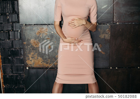 Crop of elegant pregnant woman in pink dress 50182088