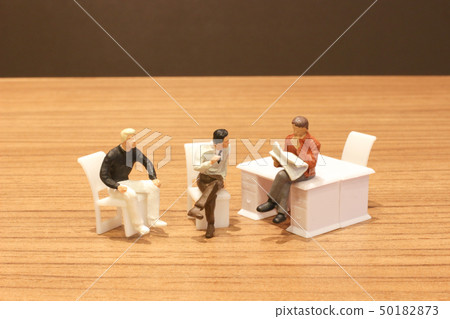 Mini people sit and read the newsapaper Mini people sit and read the newsapaper 50182873