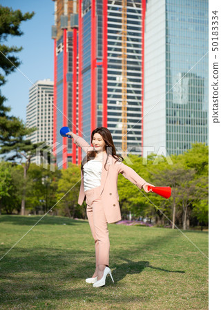 享受業餘時間的女商人在漢城的汝矣島公園在一個晴朗的春天下午 享受業餘時間的女商人在漢城的汝矣島公園在一個晴朗的春天下午 50183334