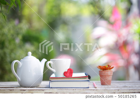 White kettle and cup with red heart and notebooks White kettle and cup with red heart and notebooks 50185265