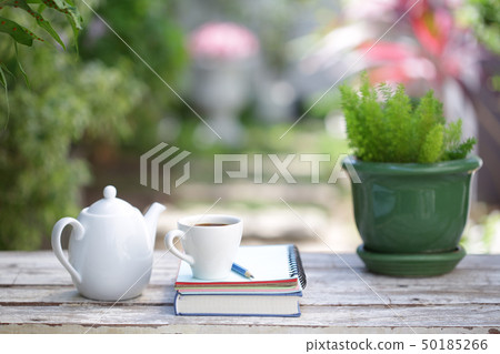 White coffee cup and notebooks on wooden table White coffee cup and notebooks on wooden table 50185266