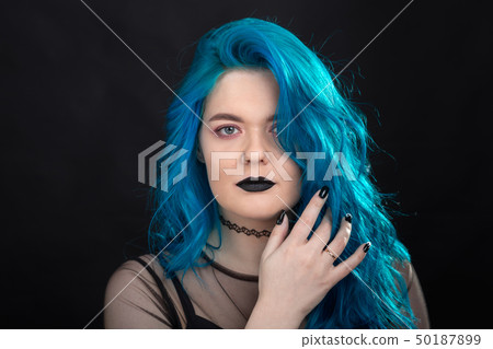People and fashion concept - Young and attractive woman with black lipstick and blue hair posing 50187899