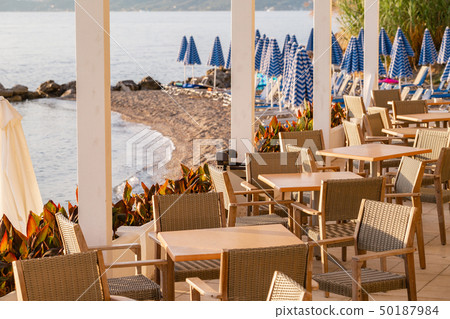 Tables in cafe. Summer sunrise on coast, Corfu island, Greece. Beach with Sunbeds and umbrellas with 50187984