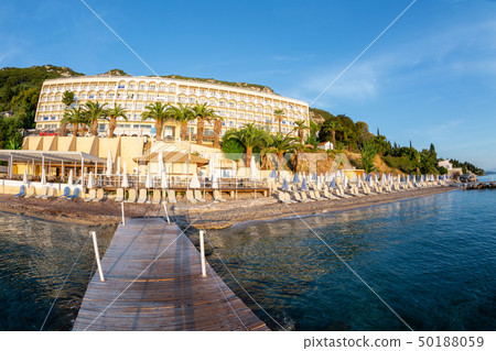 Summer sunrise on coast, Corfu island, Greece. Beach with Sunbeds and umbrellas with perfect views Summer sunrise on coast, Corfu island, Greece. Beach with Sunbeds and umbrellas with perfect views 50188059