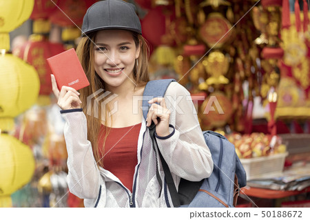 Young asian woman traveler bag backpacker holding red passport f Young asian woman traveler bag backpacker holding red passport f 50188672