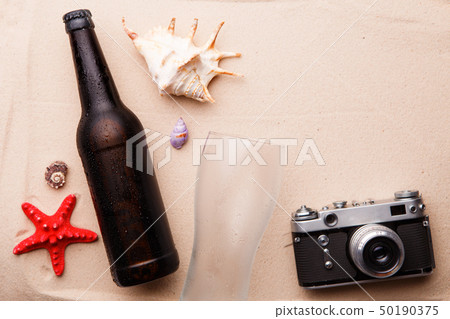 Beer bottle and glass on a sandy beach. Beer bottle and glass on a sandy beach. 50190375