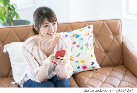 Woman operating a smartphone Woman operating a smartphone 50194284