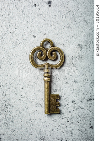 Old key on old gray concrete background. Old key on old gray concrete background. 50195014