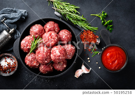 Fresh raw beef meatballs with spices and tomato 50195258