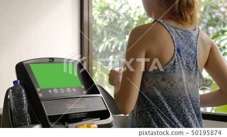 Young caucasian girl running on the treadmill in the sport gym 50195874