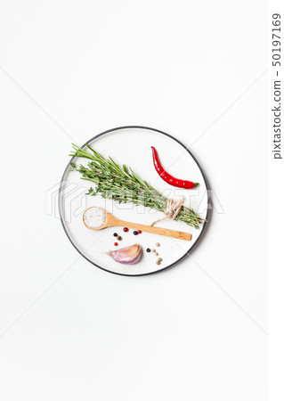 Empty plate with greens herbs and spices around Empty plate with greens herbs and spices around 50197169