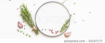 Empty plate with greens herbs and spices around Empty plate with greens herbs and spices around 50197177