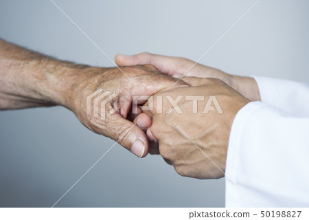 man moving the hand of a senior patient 50198827