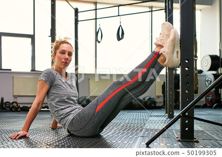 Great progress. Young beautiful woman in sportswear doing stretching in front of window at gym Great progress. Young beautiful woman in sportswear doing stretching in front of window at gym 50199305