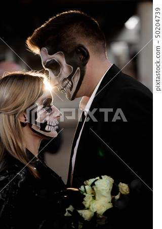 Halloween couple. Dressed in wedding clothes 50204739