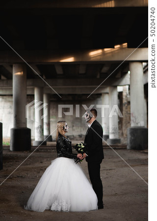 Halloween couple. Dressed in wedding clothes 50204740