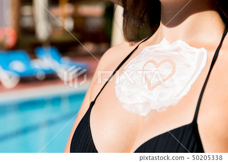 Pretty woman is applying sun cream Pretty woman is applying sun cream 50205338