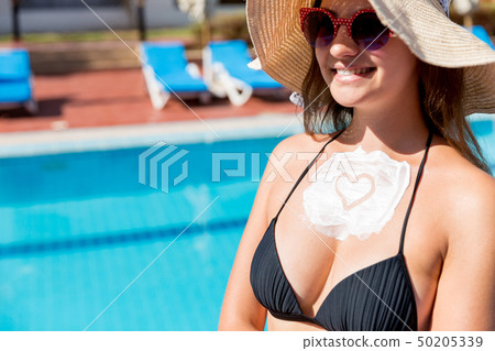 Pretty woman is applying sun cream Pretty woman is applying sun cream 50205339