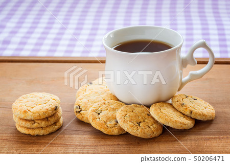 White porcelain cup with tea and oatmeal cookies 50206471