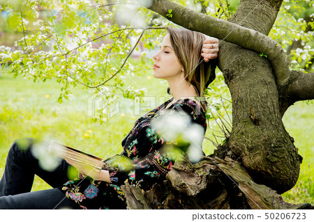 woman with book in springtime park. 50206723